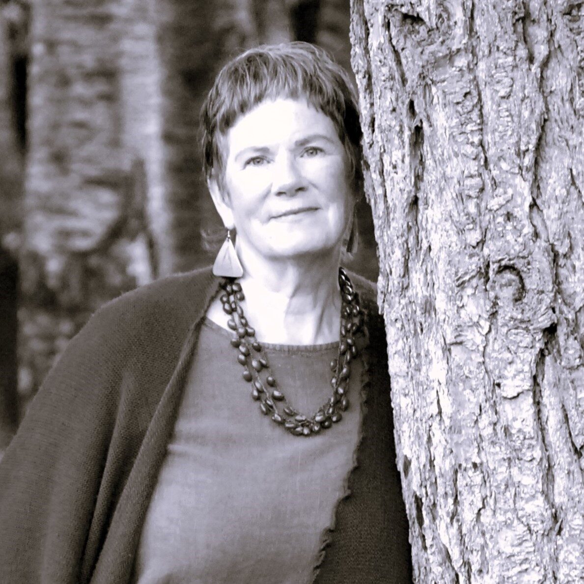 carrie kenner doula trainer leans against a large tree